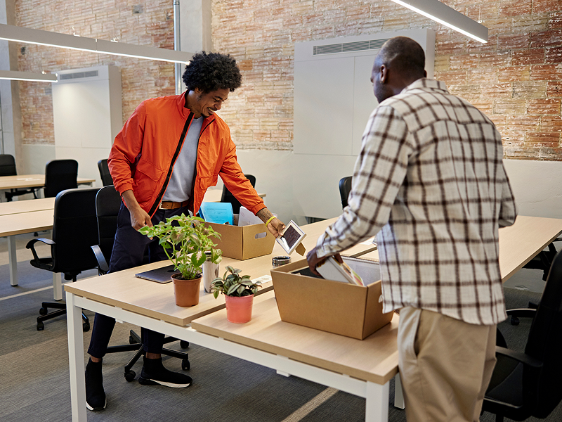 Office colleagues packing belongings in boxes