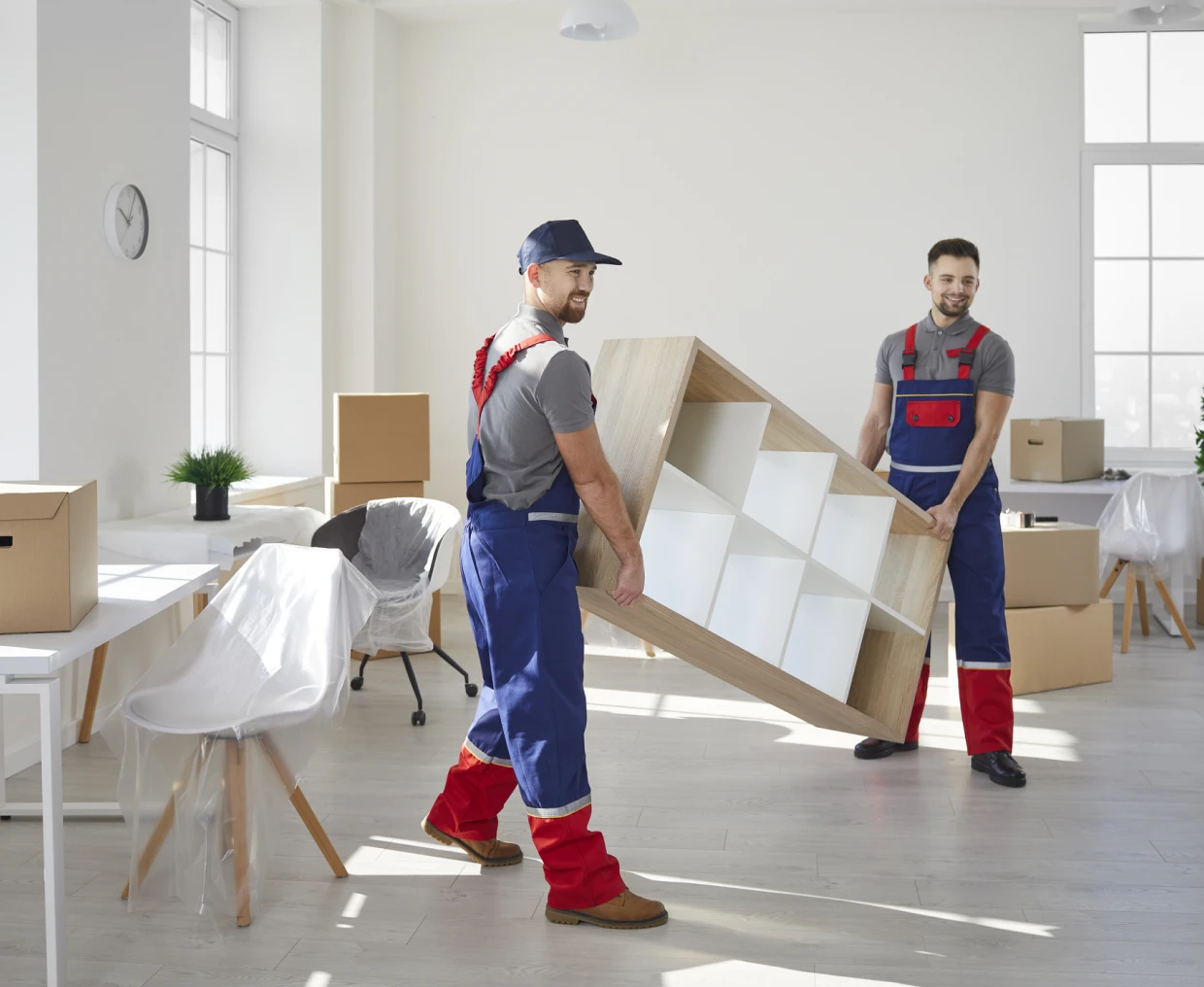 Workers lifting furniture in bright room