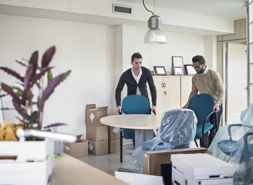 Colleagues preparing a meeting room setup