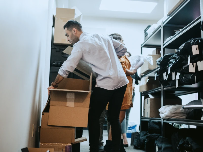 People organizing boxes in storage room